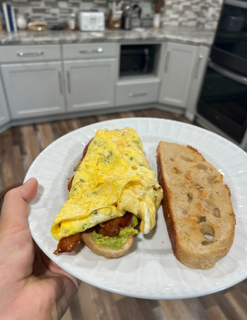 Open bacon, egg, cheese, and avocado sandwich.